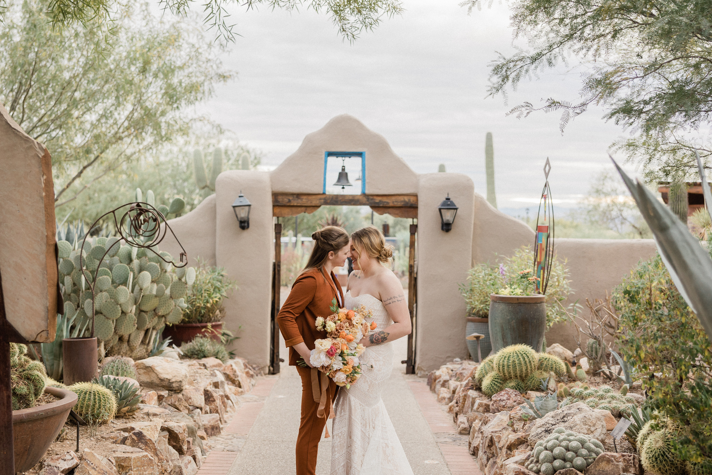 Newlywed Couple with Bridal Bouquets Kissing Outdoors